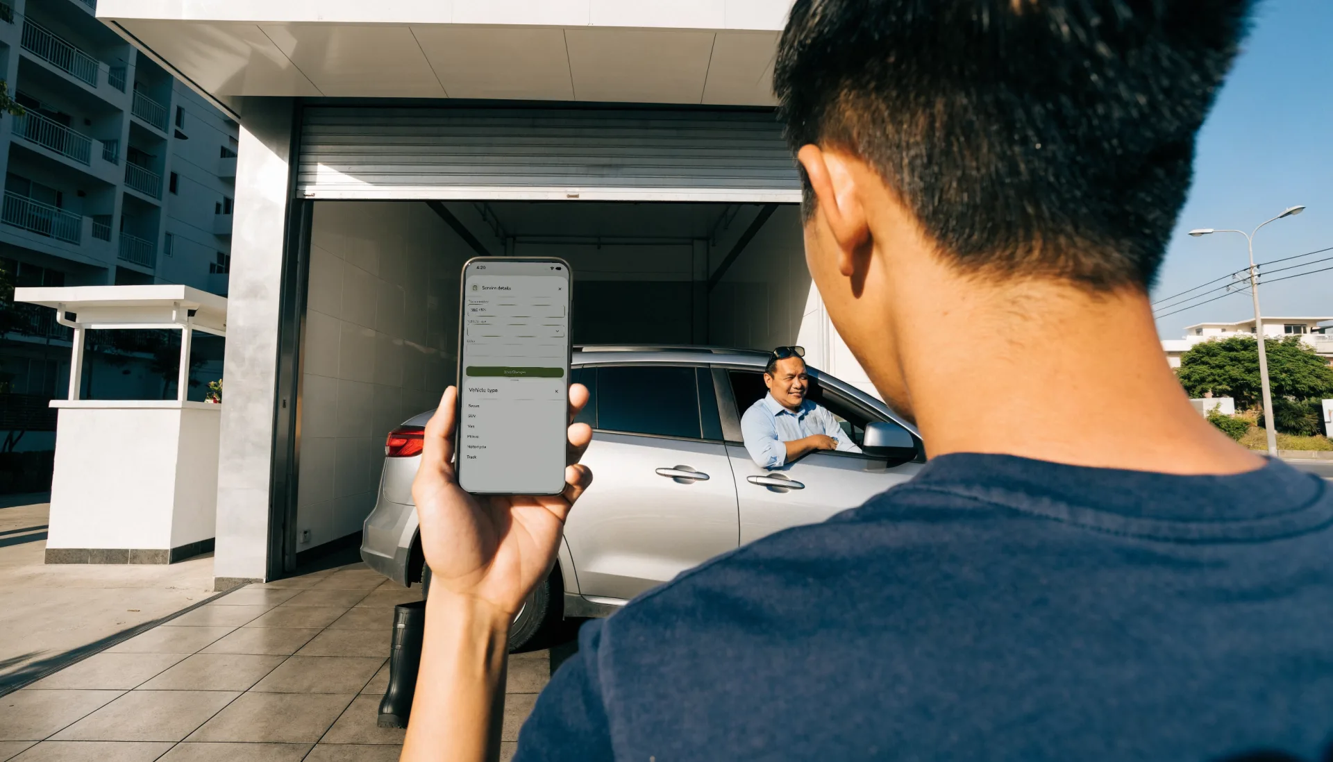 At the entrance an attendant enters an arriving SUV’s plate number and vehicle type in Fuze Store on his phone while the driver waits at the window.